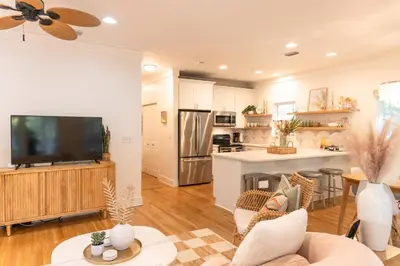 a living room with a television and a kitchen at Glory Days 30A - Pool, Bikes & Close Beach Access in Inlet Beach