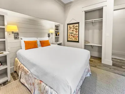a bedroom with a large white bed with orange pillows at 224 Winston Ln l 4 Bikes Included l Beachfront with Amazing view l Community Pool in Inlet Beach