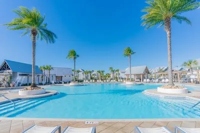 a large swimming pool with palm trees in a resort at Absolutely Paradise II l Heated 5000 sqft resort style pool l Walk to many restaurants in Santa Rosa Beach