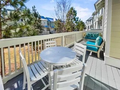 a patio with a table and chairs on a deck at Absolutely Paradise II l Heated 5000 sqft resort style pool l Walk to many restaurants in Santa Rosa Beach