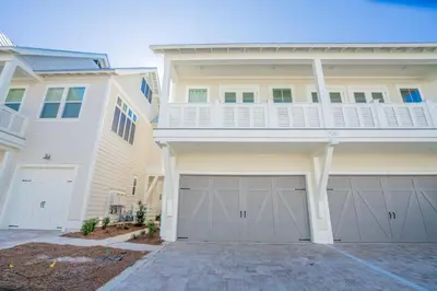 a house with two garage doors in front of it at Absolutely Paradise II l Heated 5000 sqft resort style pool l Walk to many restaurants in Santa Rosa Beach