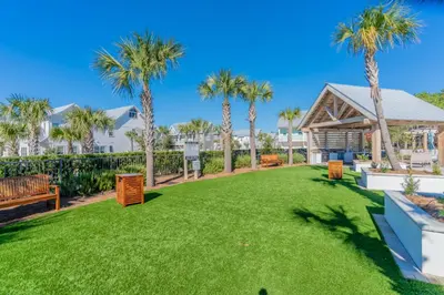 a large yard with palm trees and a pavilion at Absolutely Paradise II l Heated 5000 sqft resort style pool l Walk to many restaurants in Santa Rosa Beach