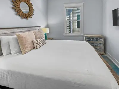 a bedroom with a large white bed with a mirror at Absolutely Paradise II l Heated 5000 sqft resort style pool l Walk to many restaurants in Santa Rosa Beach