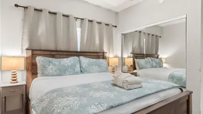 a bedroom with two beds with blue pillows at Beachfront Condo Oceanview Balcony Lagoon Pool Thomas Dr 2308 by AvantStay in Panama City Beach