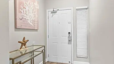 a white door in a room with a glass table at Beachfront Condo Oceanview Balcony Lagoon Pool Thomas Dr 2308 by AvantStay in Panama City Beach