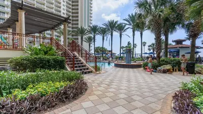 a resort with a swimming pool and palm trees at Beachfront Condo Oceanview Balcony Lagoon Pool Thomas Dr 2308 by AvantStay in Panama City Beach