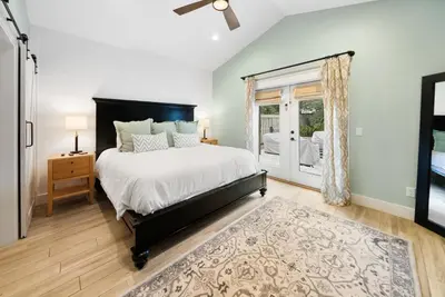 a bedroom with a large bed and a window at Bid A Wee Bungalow l Outdoor living l Private Pool & Private Beach Access l EV Charging in Panama City Beach