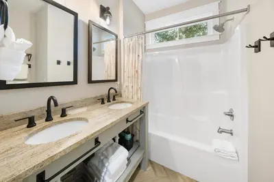 a bathroom with two sinks and a shower at Bid A Wee Bungalow l Outdoor living l Private Pool & Private Beach Access l EV Charging in Panama City Beach