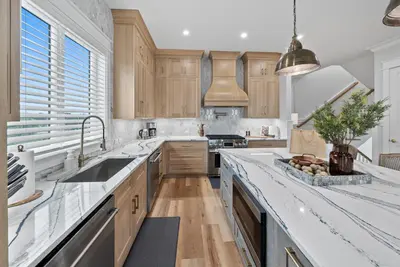 a kitchen with wooden cabinets and a white counter top at Blessings at Pier Park l Luxury l Gulf Front Oasis with Private Pool l Steps From Pier Park in Panama City Beach