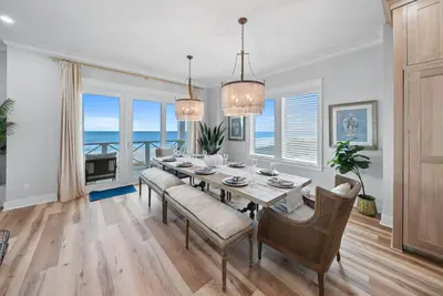 a dining room with a table and chairs and the ocean at Blessings at Pier Park l Luxury l Gulf Front Oasis with Private Pool l Steps From Pier Park in Panama City Beach