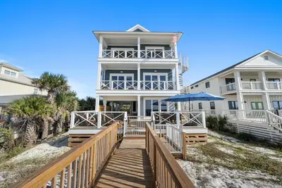 a house on the beach with a wooden walkway at Blessings at Pier Park l Luxury l Gulf Front Oasis with Private Pool l Steps From Pier Park in Panama City Beach