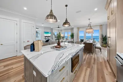 an open kitchen and living room with a large island at Blessings at Pier Park l Luxury l Gulf Front Oasis with Private Pool l Steps From Pier Park in Panama City Beach