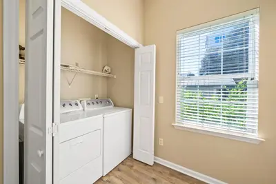 a laundry room with a washer and dryer and a window at Blue Palm l Minutes to Sandy White Beach l Bike to Rosemary Beach in Inlet Beach