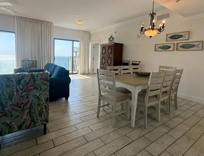 a dining room and living room with a table and chairs at Origins at Seahaven 1504 in Panama City Beach