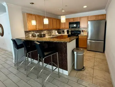 a kitchen with a island with bar stools at Origins at Seahaven 1504 in Panama City Beach
