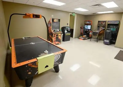a room with a ping pong table and arcade games at Origins at Seahaven 1429 in Panama City Beach
