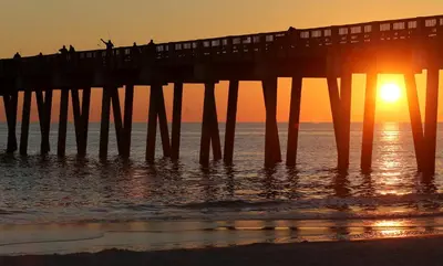 a pier with people on it at sunset at Origins at Seahaven 1429 in Panama City Beach