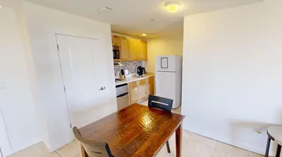 a kitchen with a wooden table and a refrigerator at Origins at Seahaven 709 in Panama City Beach