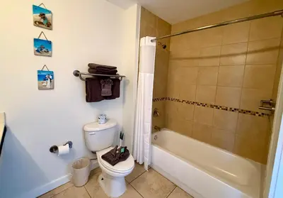 a bathroom with a shower and a toilet and a tub at Origins at Seahaven 709 in Panama City Beach