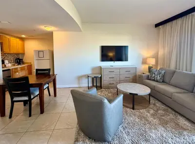 a living room with a couch and a table at Origins at Seahaven 709 in Panama City Beach