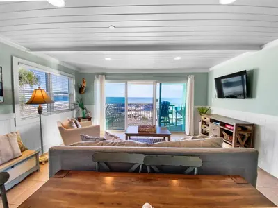 a living room with a couch and a view of the ocean at Commodores 101 l Beachfront l Corner Unit with Pristine Beach Views l Community Pool in Santa Rosa Beach