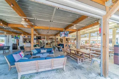 a patio with tables and benches and tablesktop at Commodores 101 l Beachfront l Corner Unit with Pristine Beach Views l Community Pool in Santa Rosa Beach