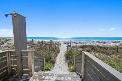 a stairway to the beach with the ocean in the background at Eastern Shores 101 l Beachfront l Ground level with direct access to beach and pristine views in Santa Rosa Beach