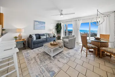a living room with a couch and a table at Eastern Shores 101 l Beachfront l Ground level with direct access to beach and pristine views in Santa Rosa Beach