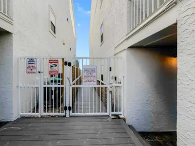 a gate to a building with signs on it at Eastern Shores 101 l Beachfront l Ground level with direct access to beach and pristine views in Santa Rosa Beach