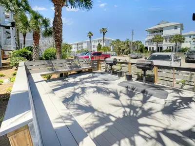 a park bench with palm trees and a parking lot at Eastern Shores 101 l Beachfront l Ground level with direct access to beach and pristine views in Santa Rosa Beach