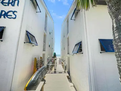 a hallway between two buildings with a inflatable boat on it at Eastern Shores 206 l Beachfront l Pristine Beach Views l 2 Bikes included in Santa Rosa Beach