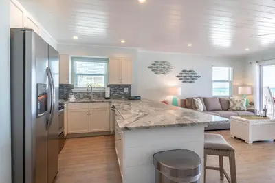 a kitchen and living room with a large counter top at Eastern Shores 206 l Beachfront l Pristine Beach Views l 2 Bikes included in Santa Rosa Beach