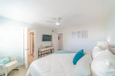 a white bedroom with a bed and a couch at Eastern Shores 206 l Beachfront l Pristine Beach Views l 2 Bikes included in Santa Rosa Beach