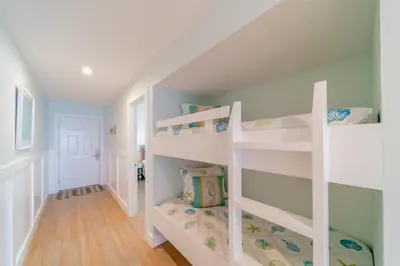 a room with white bunk beds in a house at Eastern Shores 206 l Beachfront l Pristine Beach Views l 2 Bikes included in Santa Rosa Beach