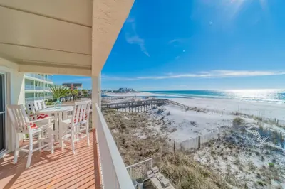 a balcony with a table and chairs and the beach at Eastern Shores 206 l Beachfront l Pristine Beach Views l 2 Bikes included in Santa Rosa Beach