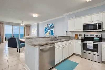 a kitchen with a sink and a stove top oven at Emerald Isle l Beachfront l Amazing beach views l Heated Community Pool l Fitness center in Panama City Beach