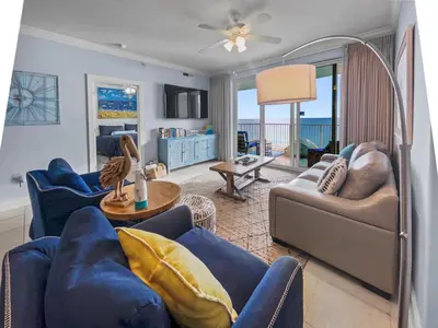 a living room with blue furniture and the ocean at Emerald Isle l Beachfront l Amazing beach views l Heated Community Pool l Fitness center in Panama City Beach