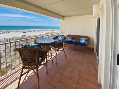 a balcony with a table and chairs and the beach at Endless Waves 208 l Beachfront l Stunning Beach Views l Bike to Seaside in Santa Rosa Beach