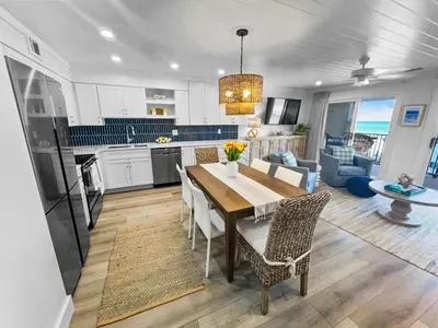 a kitchen and dining room with a table and chairs at Endless Waves 208 l Beachfront l Stunning Beach Views l Bike to Seaside in Santa Rosa Beach