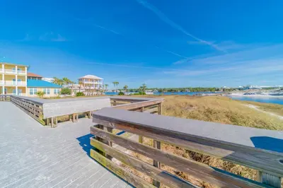 a couple of benches on a boardwalk next to the beach at Endless Waves 208 l Beachfront l Stunning Beach Views l Bike to Seaside in Santa Rosa Beach