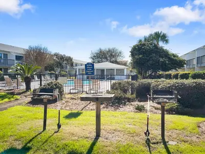 two picnic tables in a park in front of a building at Hidden Beach Villas 111 l Heated community pool l Tennis and Shuffleboard l Across from the Beach in Santa Rosa Beach