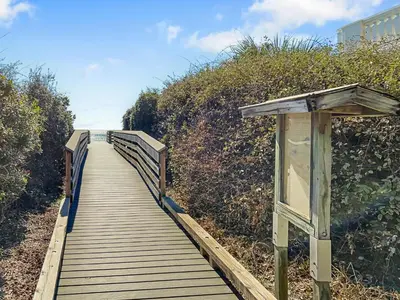 a wooden boardwalk leading down to the beach at Hidden Beach Villas 111 l Heated community pool l Tennis and Shuffleboard l Across from the Beach in Santa Rosa Beach