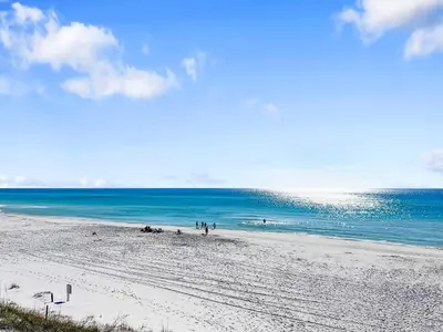 a group of people on a beach near the ocean at Hidden Beach Villas 111 l Heated community pool l Tennis and Shuffleboard l Across from the Beach in Santa Rosa Beach