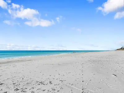 a beach with footprints in the sand and the ocean at Hidden Beach Villas 111 l Heated community pool l Tennis and Shuffleboard l Across from the Beach in Santa Rosa Beach