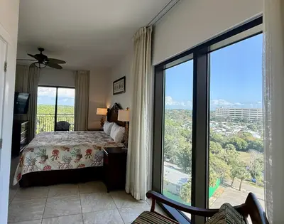 a bedroom with a bed and a large window at Origin at Seahaven 727 in Panama City Beach