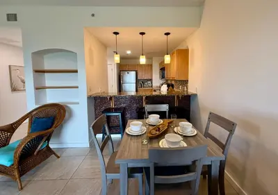a dining room and kitchen with a table and chairs at Origin at Seahaven 727 in Panama City Beach