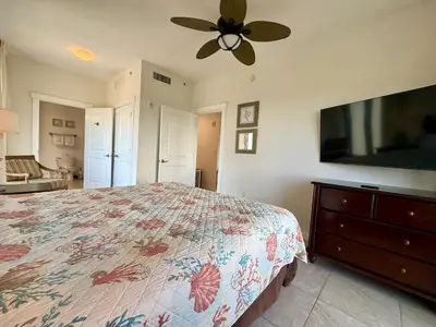 a bedroom with a bed and a flat screen tv at Origin at Seahaven 727 in Panama City Beach