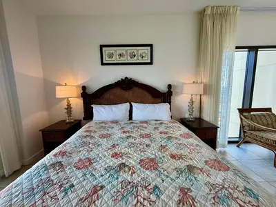 a bedroom with a large bed and two lamps at Origin at Seahaven 727 in Panama City Beach