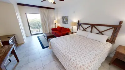 a bedroom with a bed and a red chair at Origin at Seahaven 423 in Panama City Beach