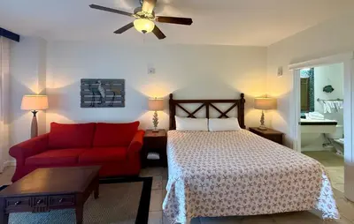 a bedroom with a bed and a red couch at Origin at Seahaven 423 in Panama City Beach